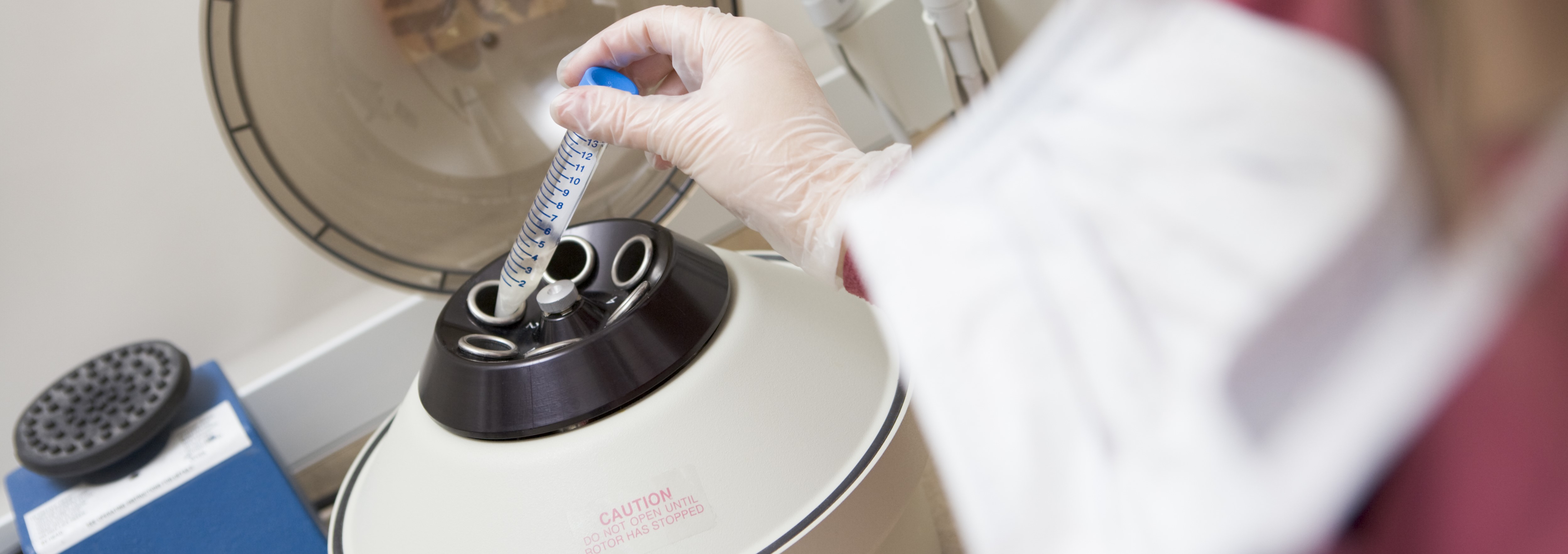 Researcher placing sample into centrifuge